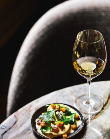 High Wine tasting setup at Royal Gate Resort, a luxury Leading Hotels of the World property, with a chilled white wine and gourmet dish.