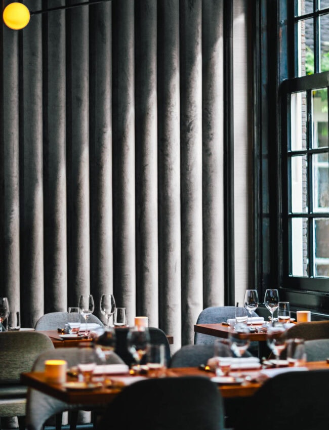 Dining tables at Bar Brasserie OCCO at Royal Gate Resort, part of Leading Hotels of the World, featuring modern lighting